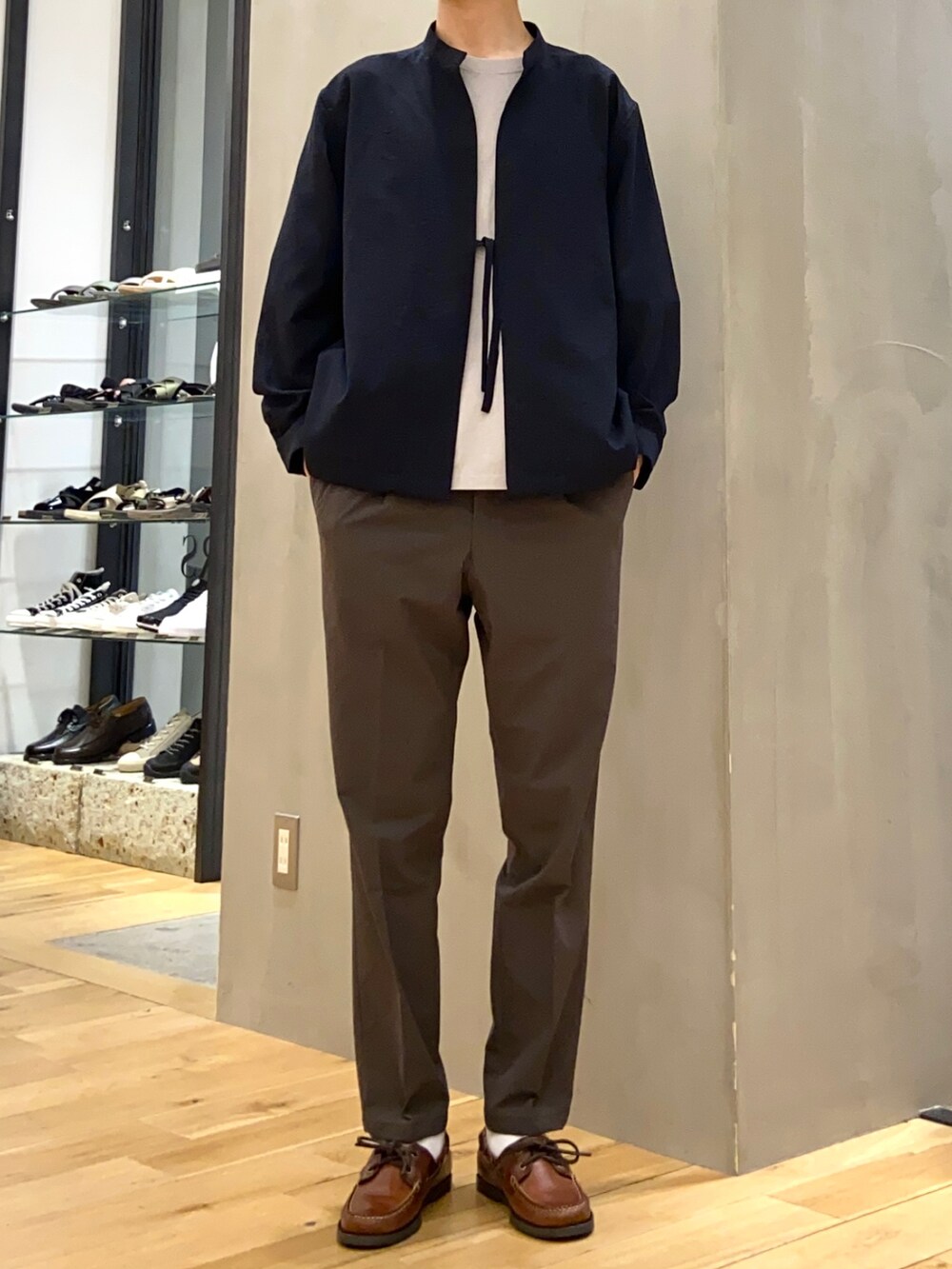 グレー系のTシャツ/カットソー、ブルー系のブルゾン、グリーン系のスーツパンツを着用したメンズの春コーディネートの2枚目の写真