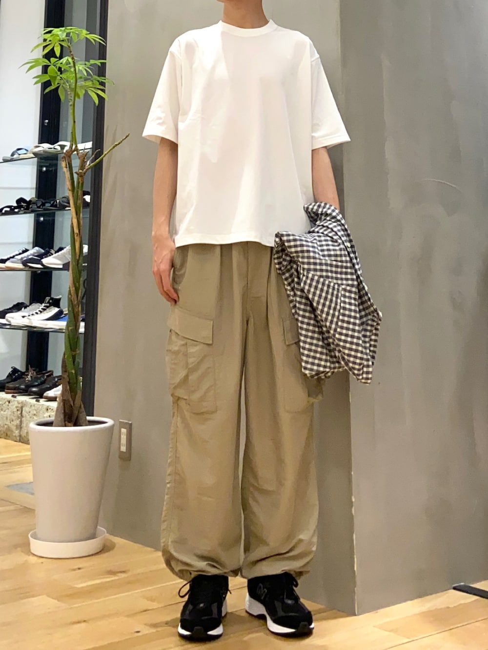 ホワイト系のTシャツ/カットソー、ベージュ系のその他パンツ、ブラック系のスニーカーを着用したメンズの春コーディネートの2枚目の写真