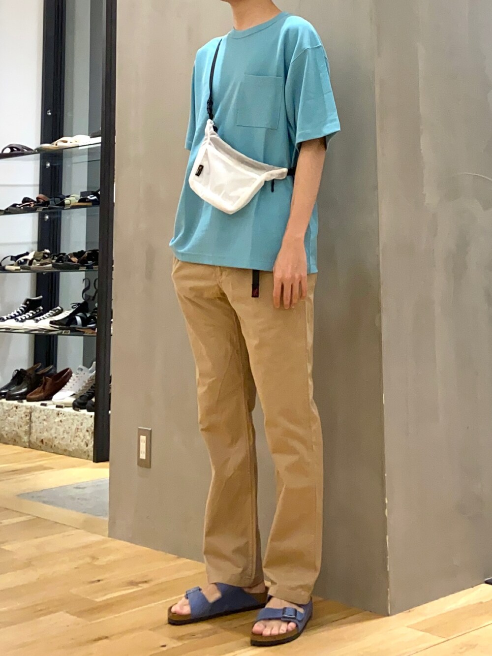 ブルー系のTシャツ/カットソー、ホワイト系のショルダーバッグ、ブルー系のサンダルを着用したメンズの春コーディネートの2枚目の写真