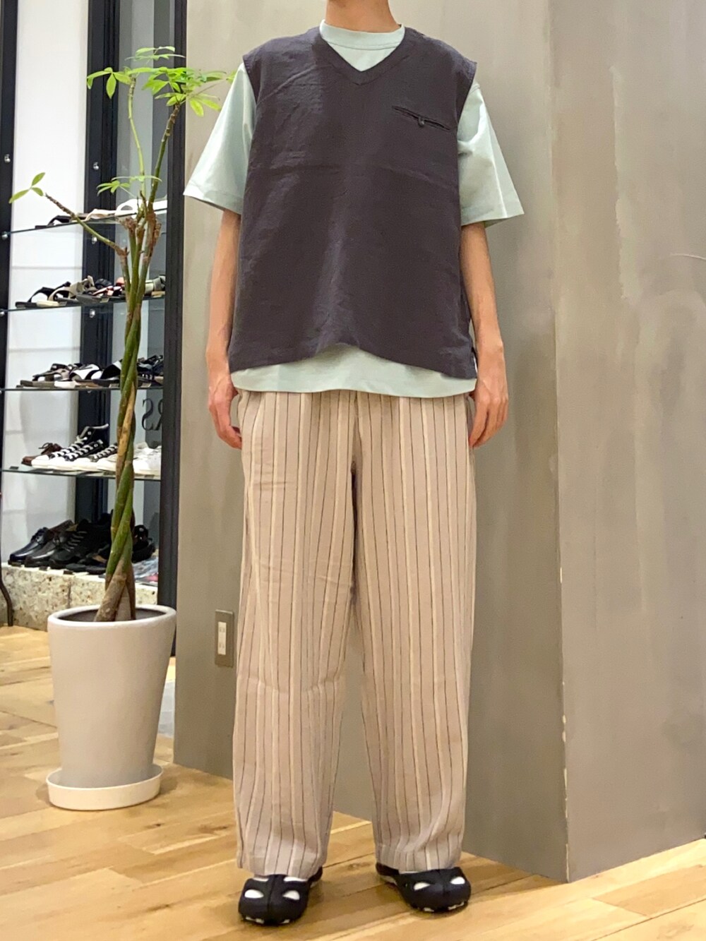 ブラック系のベスト、グリーン系のTシャツ/カットソー、ベージュ系のその他パンツを着用したメンズの夏コーディネートの3枚目の写真