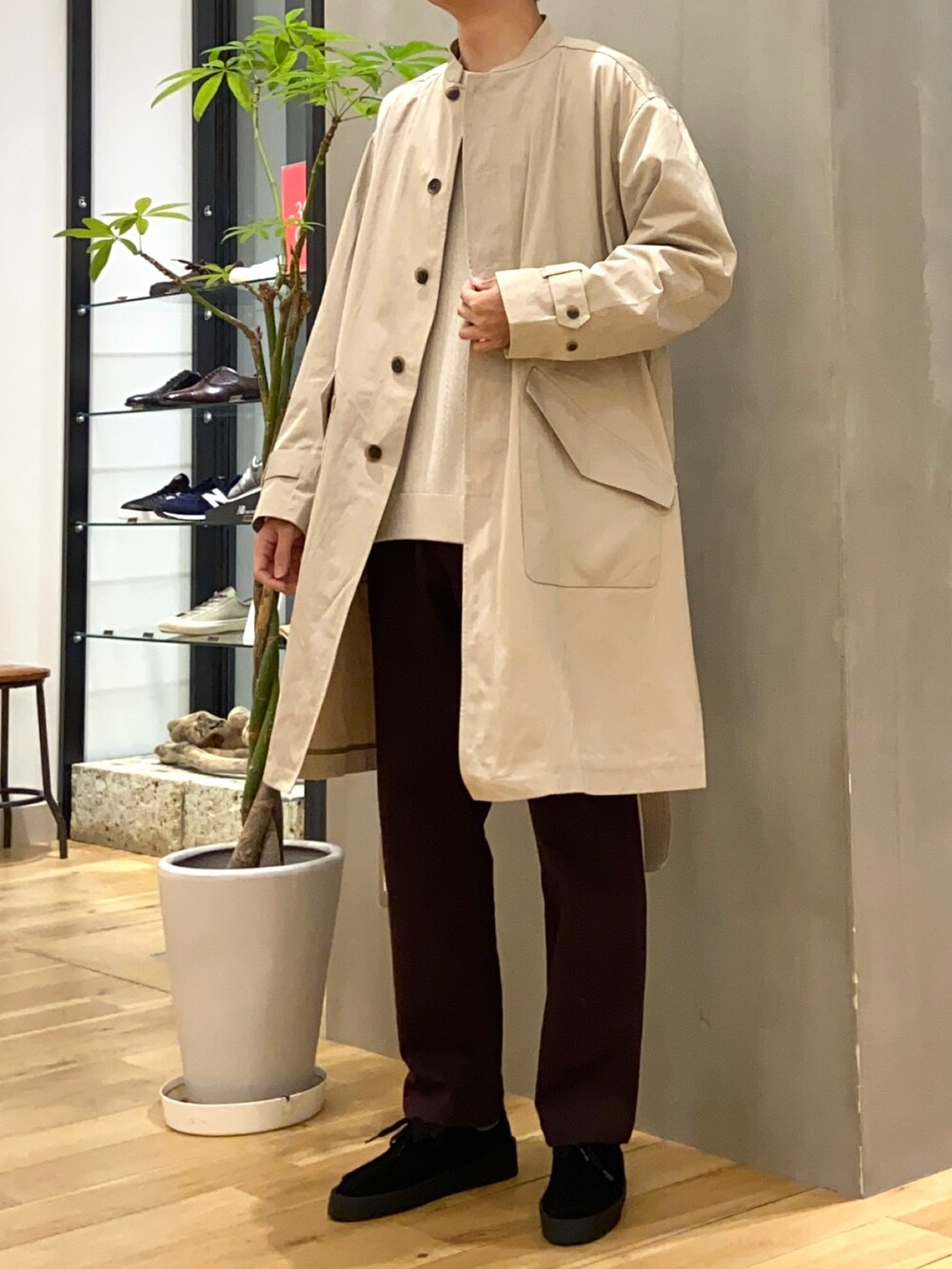 ベージュ系のステンカラーコート、ホワイト系のニット/セーター、ブラック系のその他シューズを着用したメンズの冬コーディネートの4枚目の写真