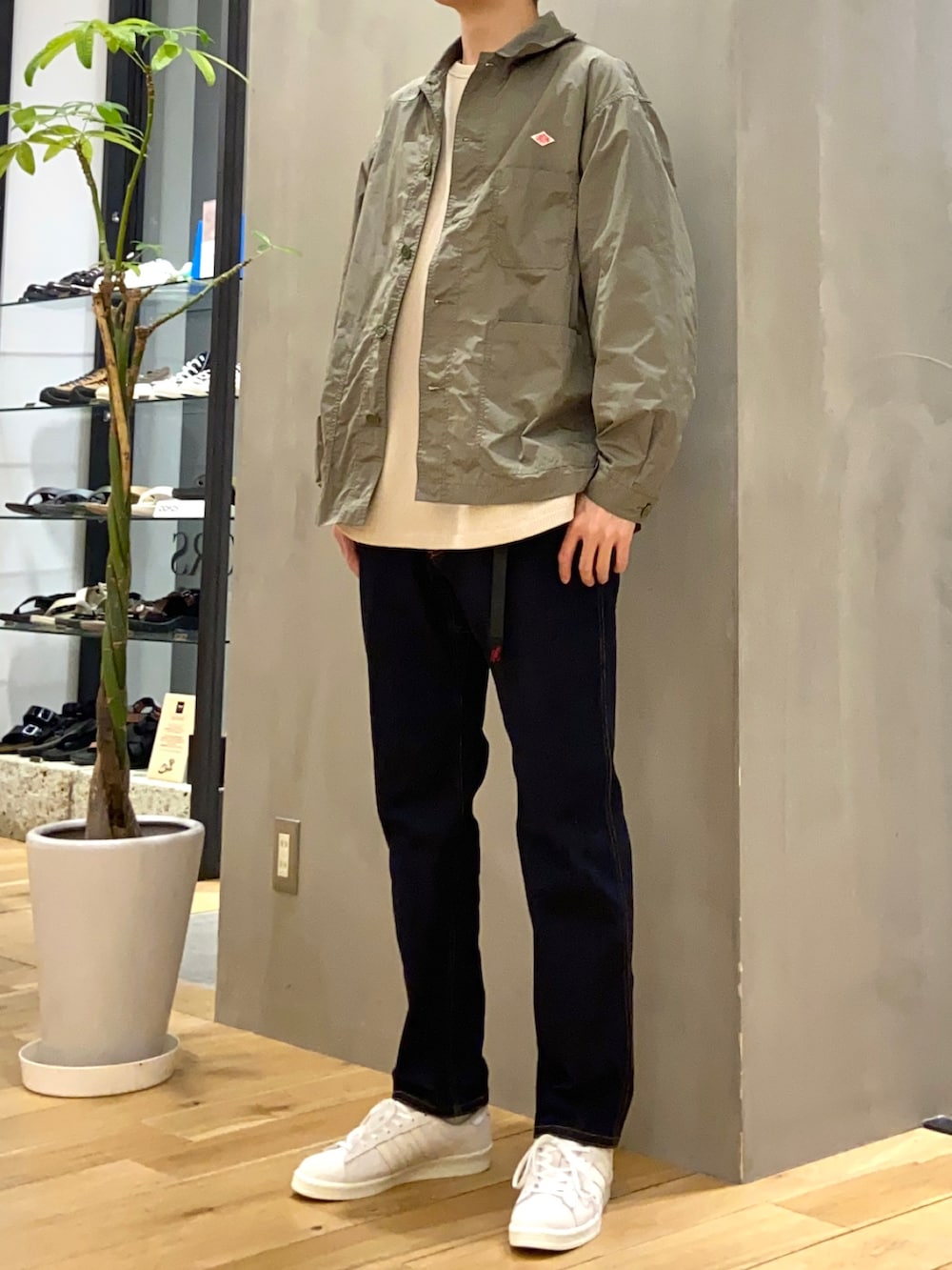 グリーン系のカバーオール、ベージュ系のTシャツ/カットソー、ブルー系のその他パンツを着用したメンズの春コーディネートの2枚目の写真