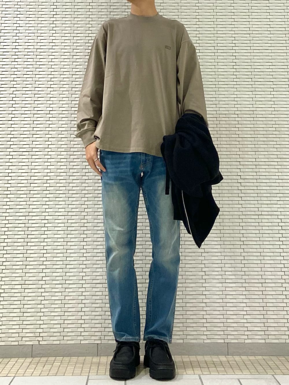 ブラック系のブルゾン、ブルー系のその他パンツ、ベージュ系のTシャツ/カットソーを着用したメンズの秋コーディネートの2枚目の写真