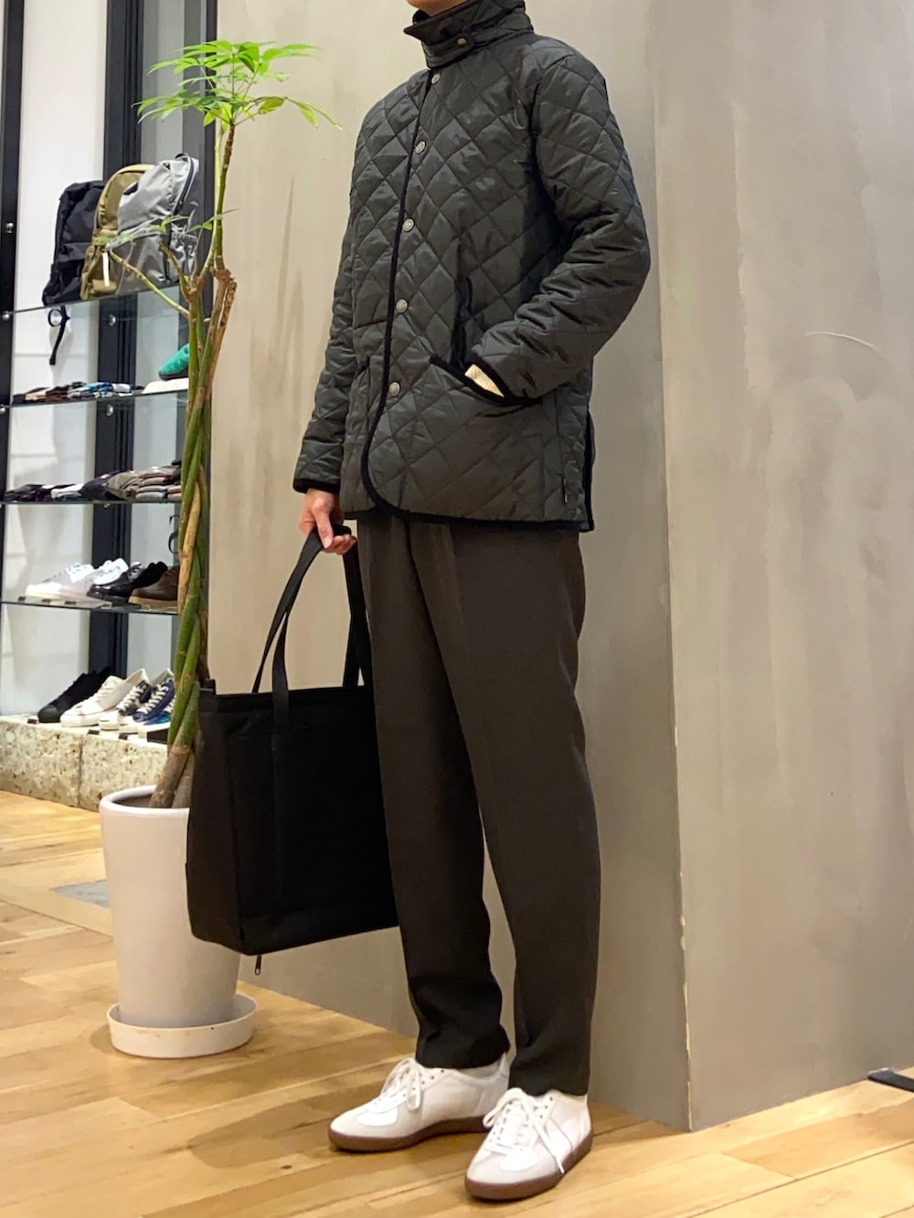 ブラック系のその他アウター、ホワイト系のニット/セーター、ホワイト系のスニーカーを着用したメンズの冬コーディネートの2枚目の写真