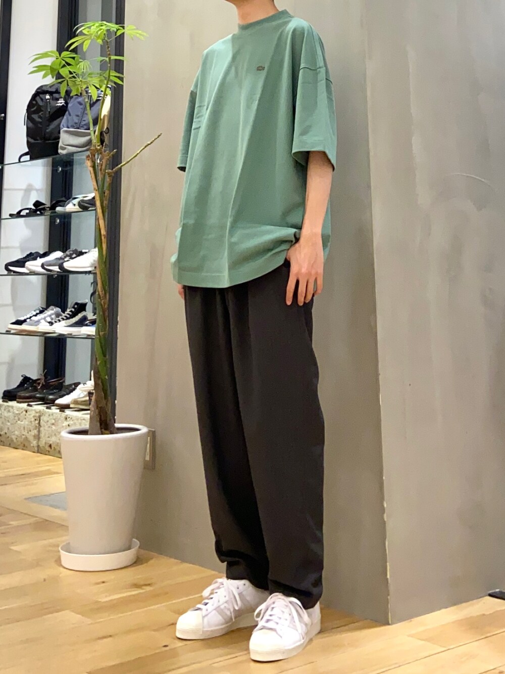 グリーン系のTシャツ/カットソー、グレー系のその他パンツ、ホワイト系のスニーカーを着用したメンズの春コーディネートの2枚目の写真
