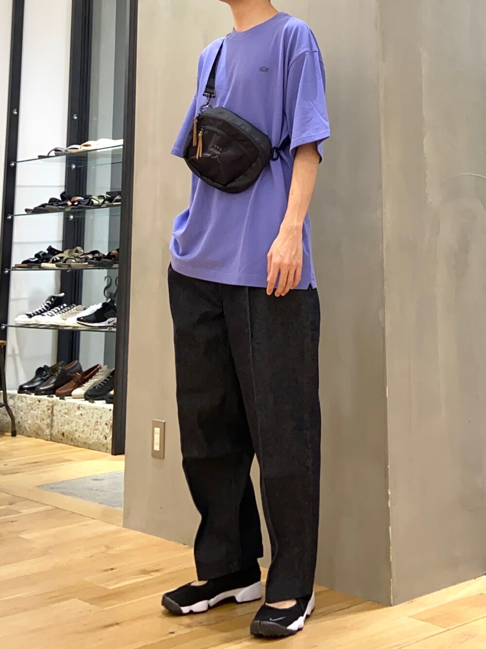パープル系のTシャツ/カットソー、ブラック系のショルダーバッグ、ブルー系のデニムパンツを着用したメンズの春コーディネートの2枚目の写真