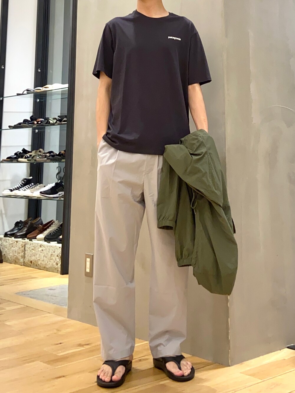 グリーン系のマウンテンパーカー、グレー系のその他パンツ、ブラック系のサンダルを着用したメンズの夏コーディネートの2枚目の写真