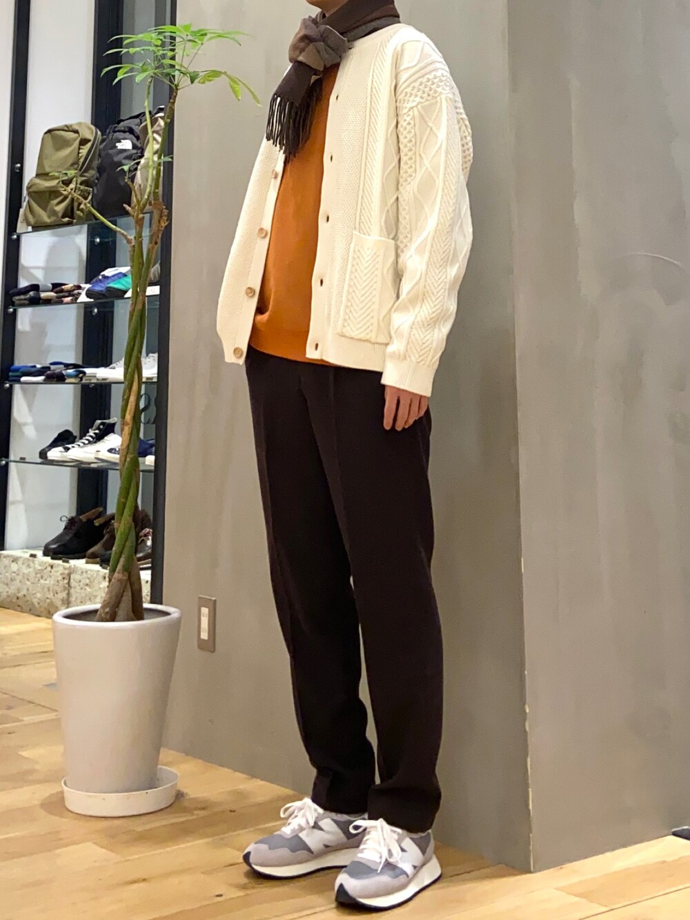 ホワイト系のカーディガン/ボレロ、ブラウン系のその他パンツ、オレンジ系のスウェットを着用したメンズの冬コーディネートの3枚目の写真