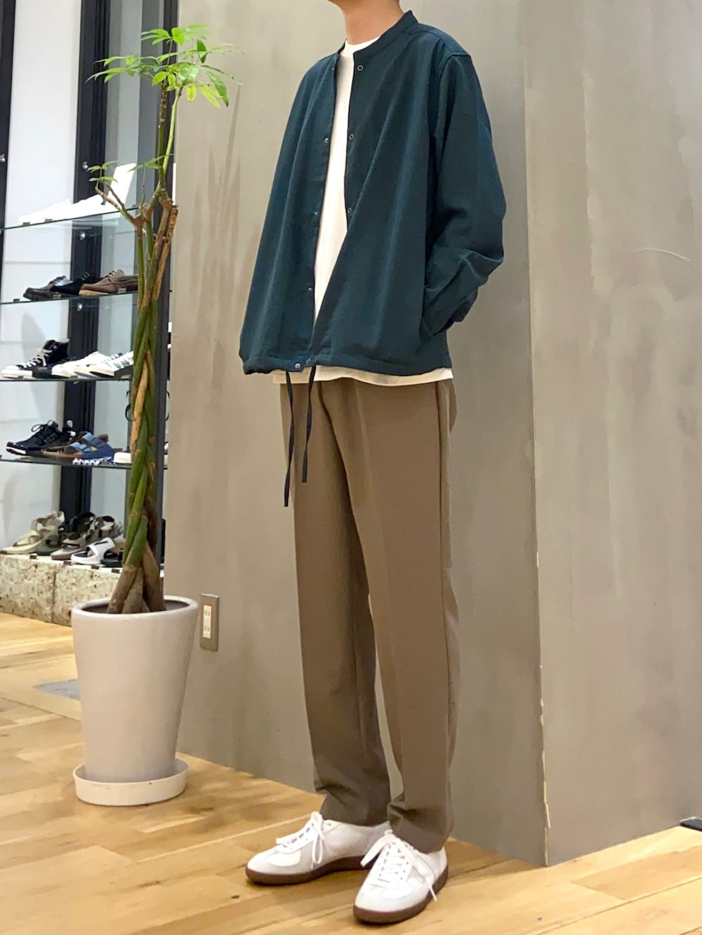 グリーン系のブルゾン、ホワイト系のTシャツ/カットソー、ホワイト系のスニーカーを着用したメンズの秋コーディネートの2枚目の写真