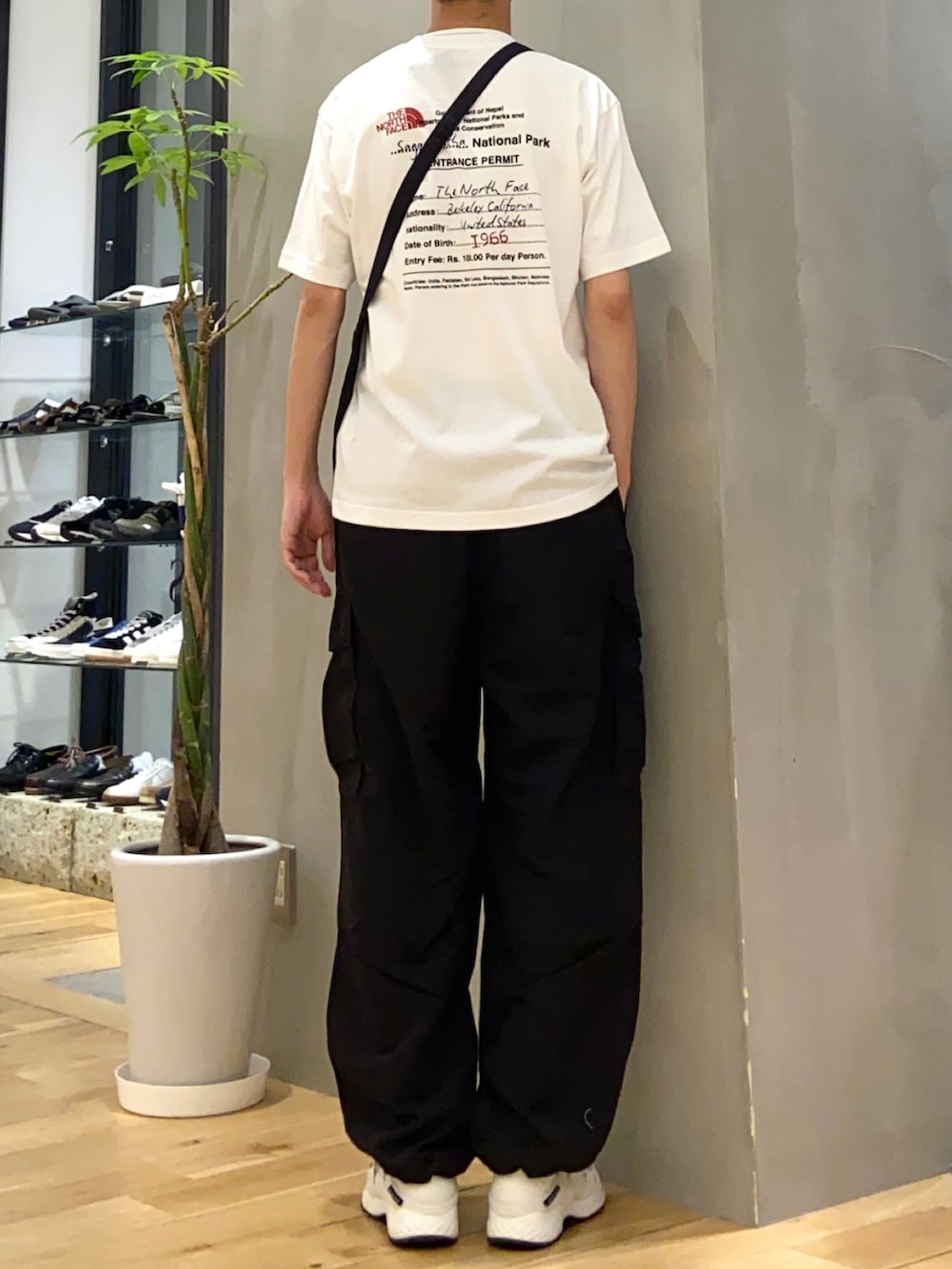 ベージュ系のTシャツ/カットソー、ブラック系のその他パンツ、ホワイト系のスニーカーを着用したメンズの春コーディネートの2枚目の写真