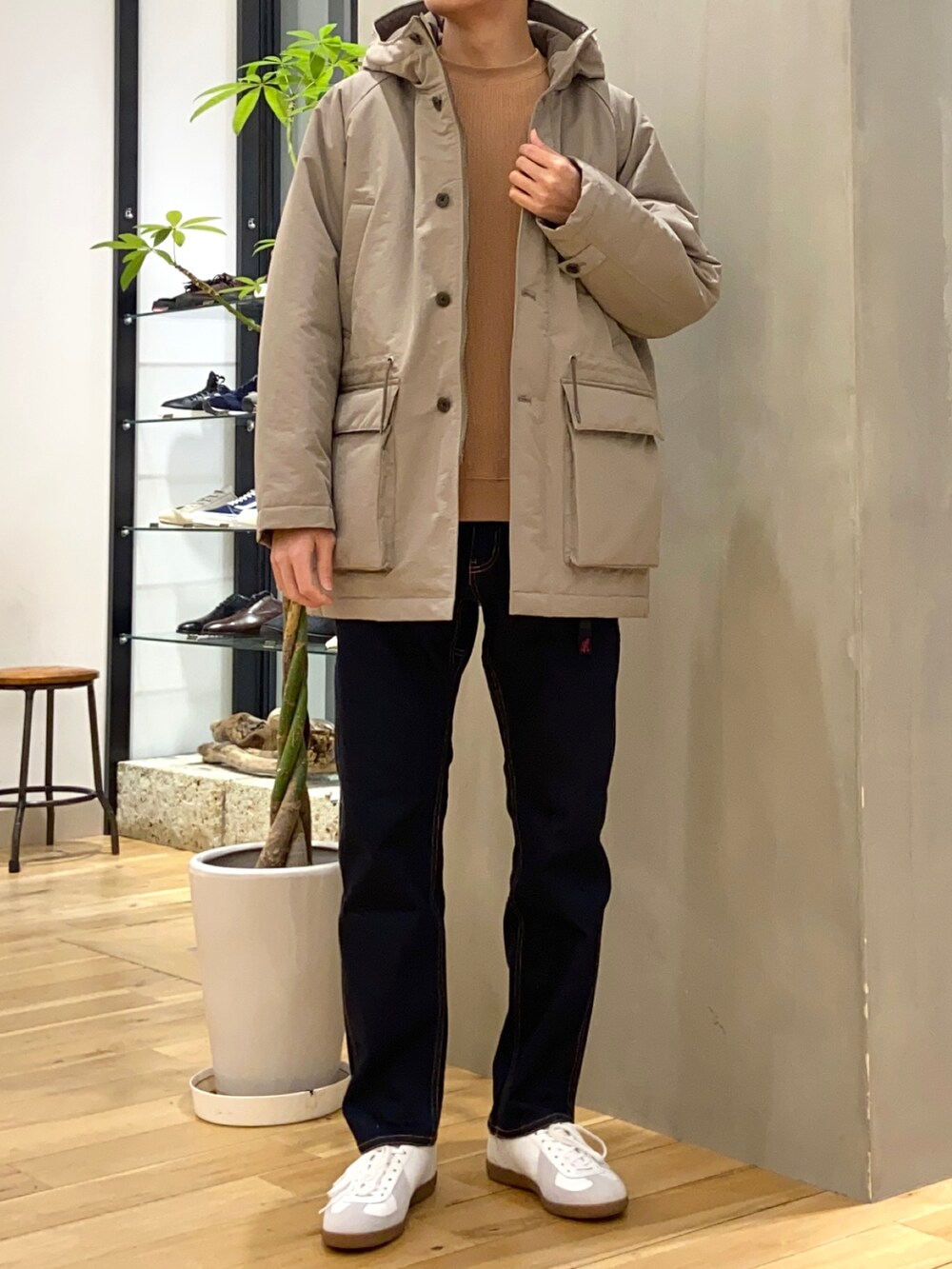 ブラウン系のダウンジャケット/コート、オレンジ系のTシャツ/カットソー、ブルー系のその他パンツを着用したメンズの冬コーディネートの3枚目の写真