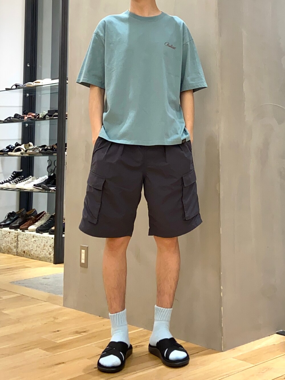 グリーン系のTシャツ/カットソー、グレー系のその他パンツ、ブラック系のサンダルを着用したメンズの春コーディネートの4枚目の写真