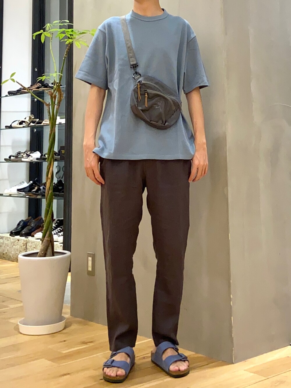 ブルー系のTシャツ/カットソー、グレー系のショルダーバッグ、グレー系のその他パンツを着用したメンズの夏コーディネートの3枚目の写真