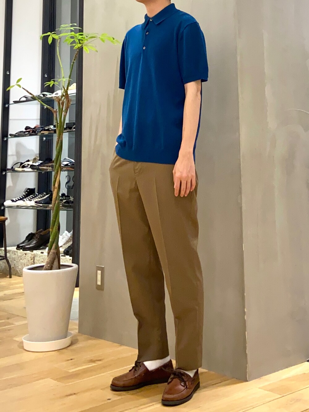ブルー系のポロシャツ、ブラウン系のその他パンツを着用したメンズの夏コーディネートの2枚目の写真