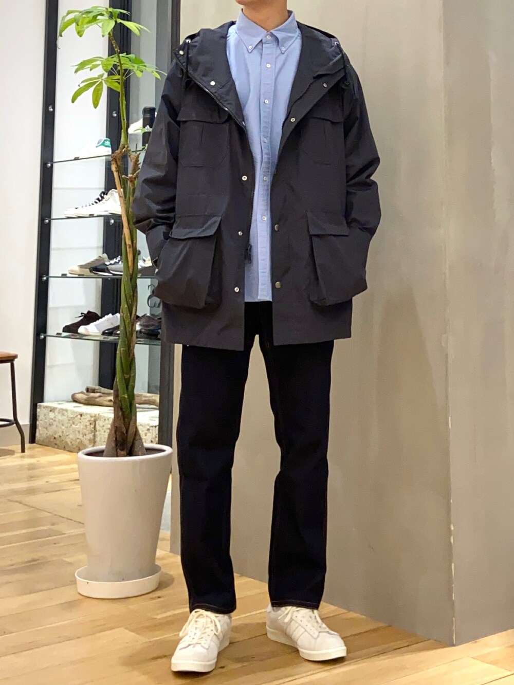 ブラック系のマウンテンパーカー、ブルー系のシャツ/ブラウス、ベージュ系のスニーカーを着用したメンズの春コーディネートの3枚目の写真