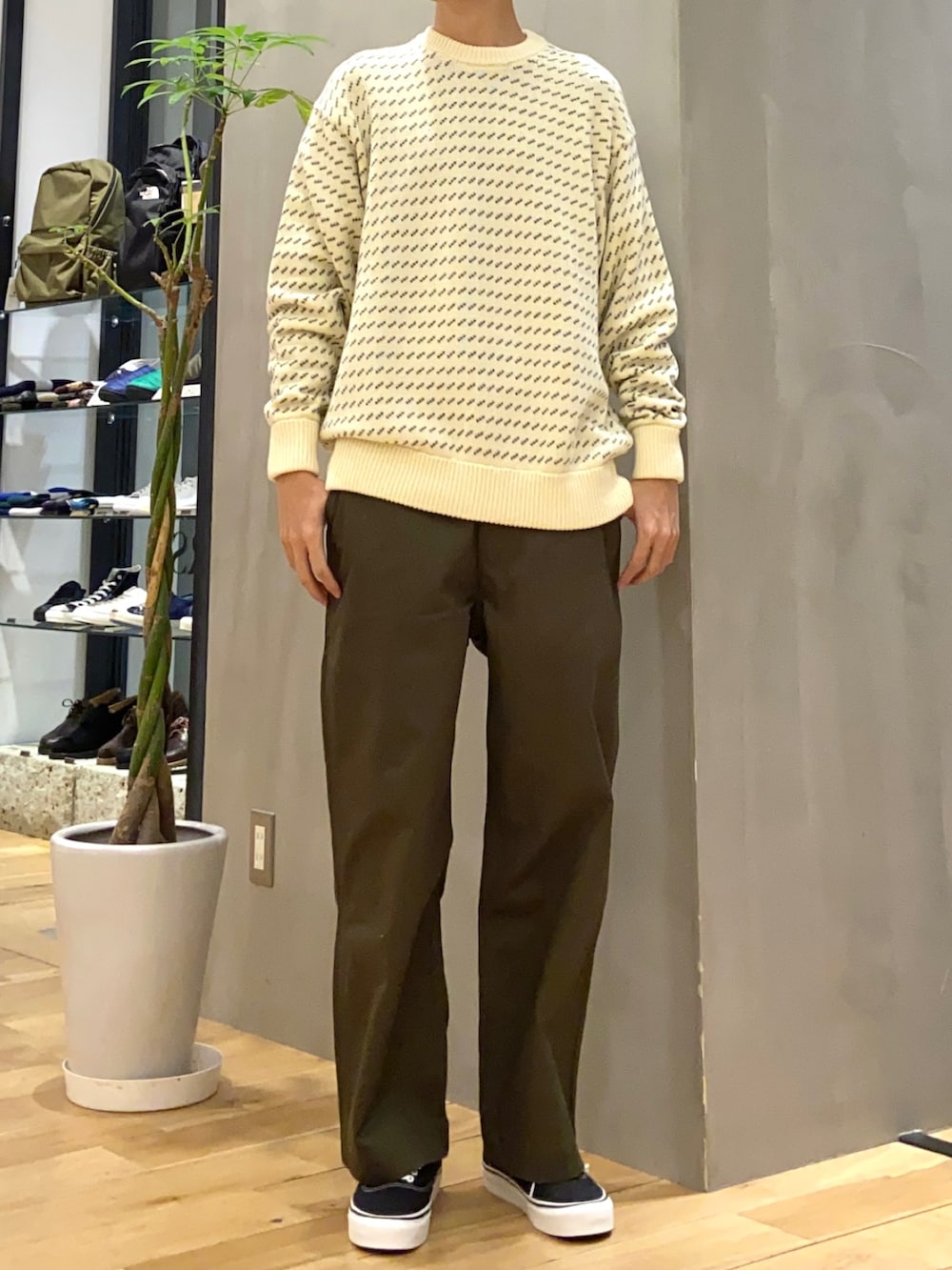 ブラック系のダウンジャケット/コート、ホワイト系のニット/セーター、ブラック系のスニーカーを着用したメンズの冬コーディネートの2枚目の写真