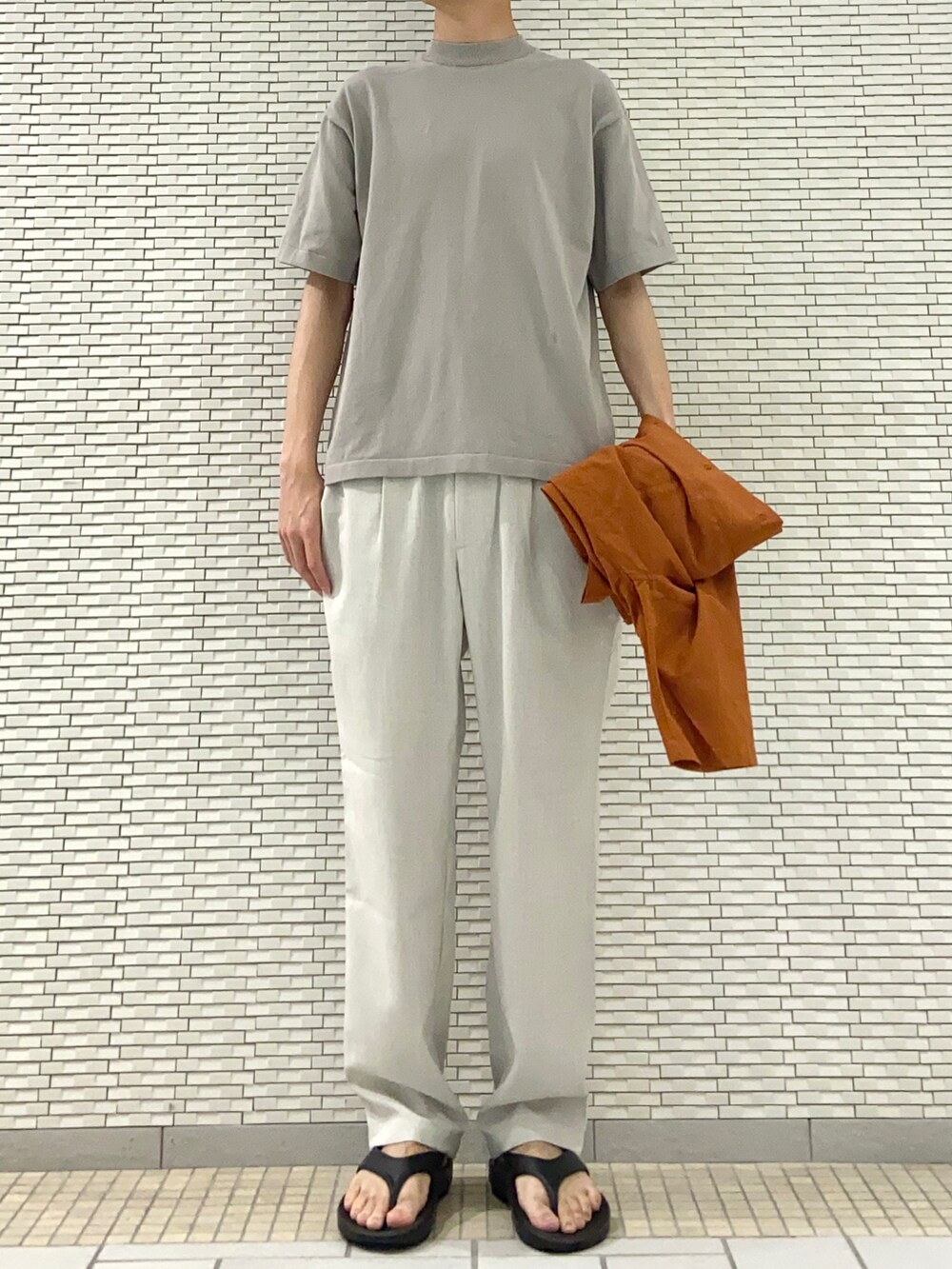 オレンジ系のシャツ/ブラウス、ベージュ系のニット/セーター、ホワイト系のその他パンツを着用したメンズの春コーディネートの2枚目の写真