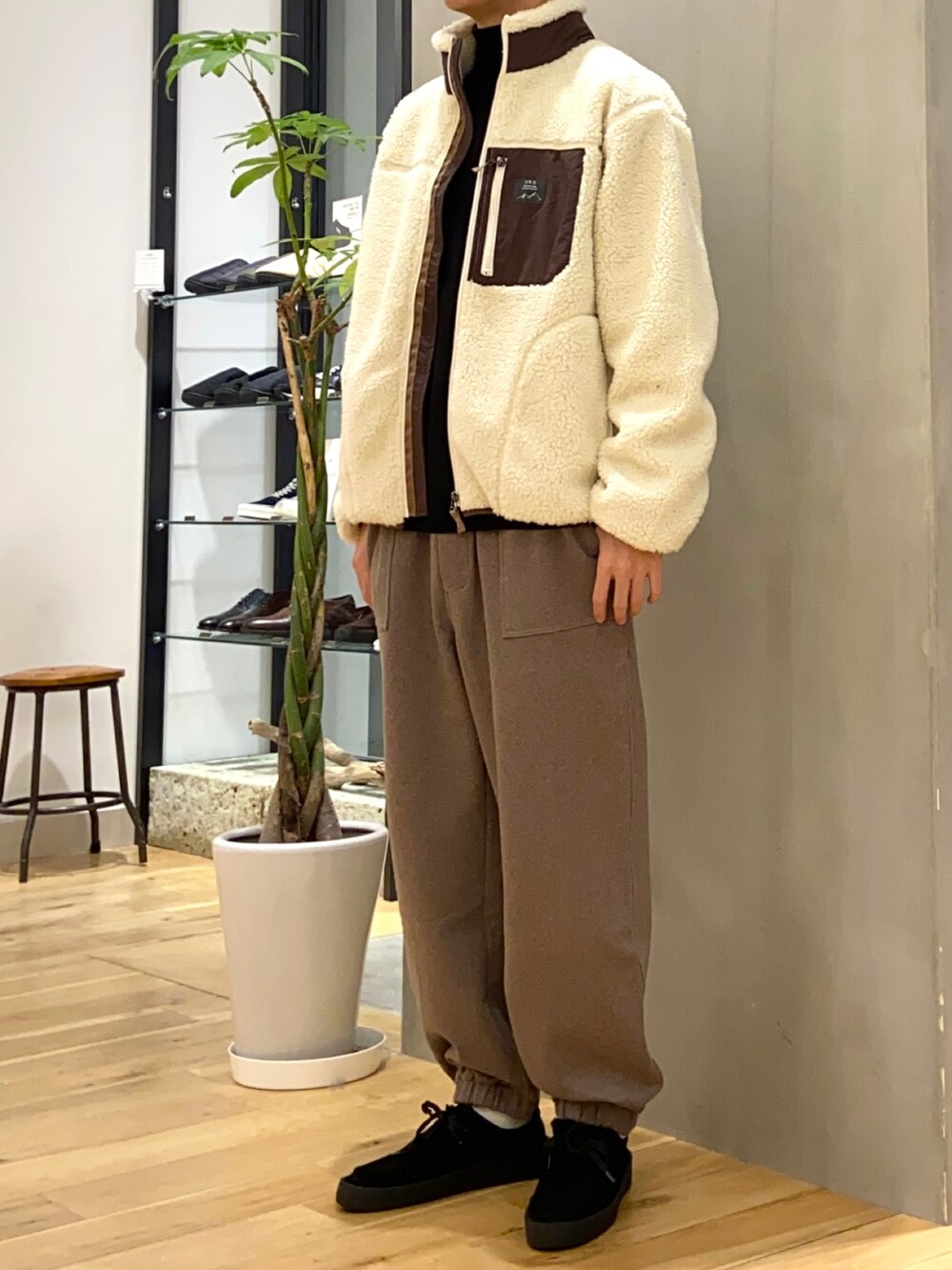 ホワイト系のブルゾン、ブラック系のニット/セーター、ブラック系のその他シューズを着用したメンズの冬コーディネートの2枚目の写真