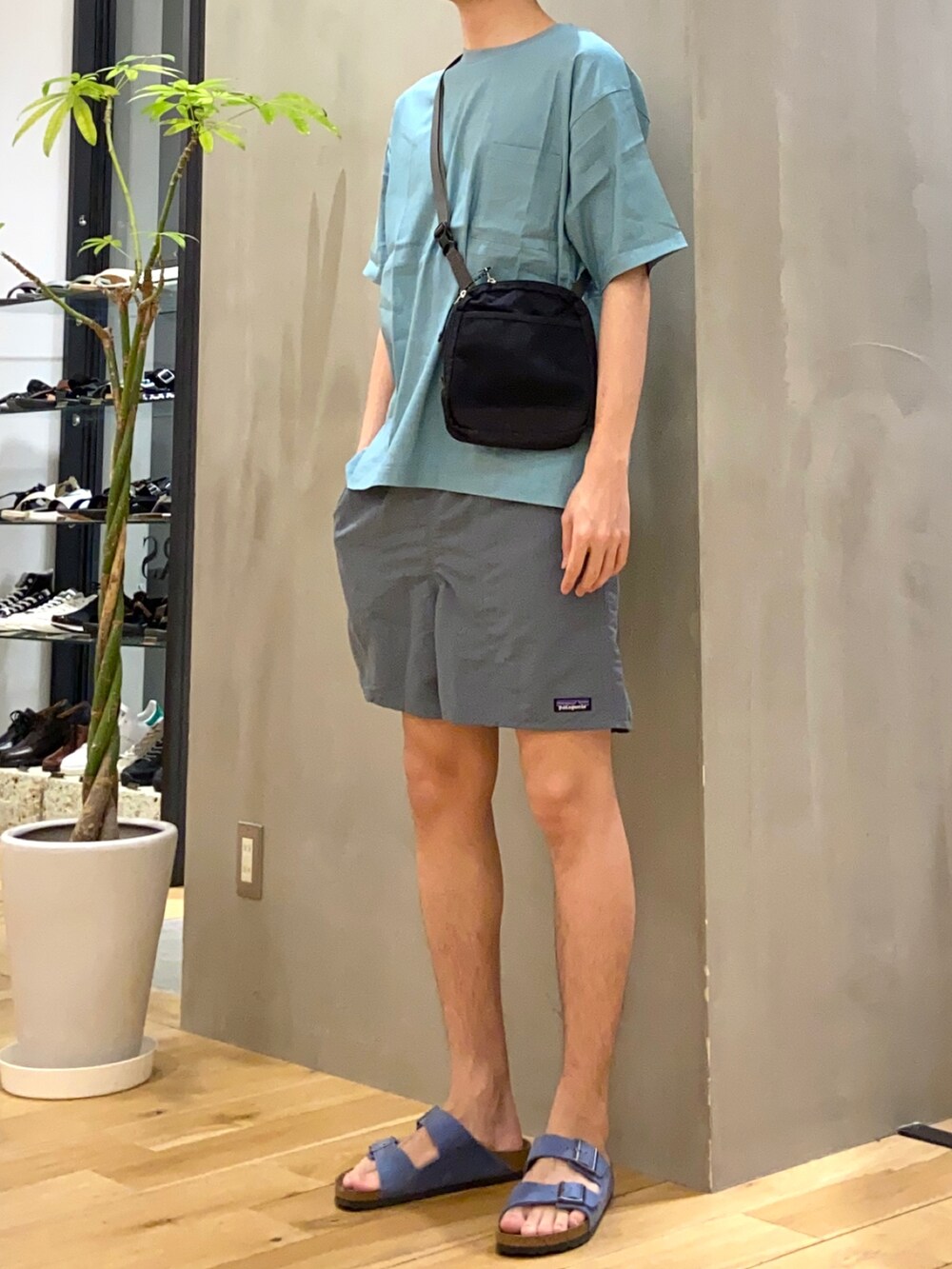 ブルー系のシャツ/ブラウス、ブラック系のショルダーバッグ、ブルー系のサンダルを着用したメンズの夏コーディネートの2枚目の写真
