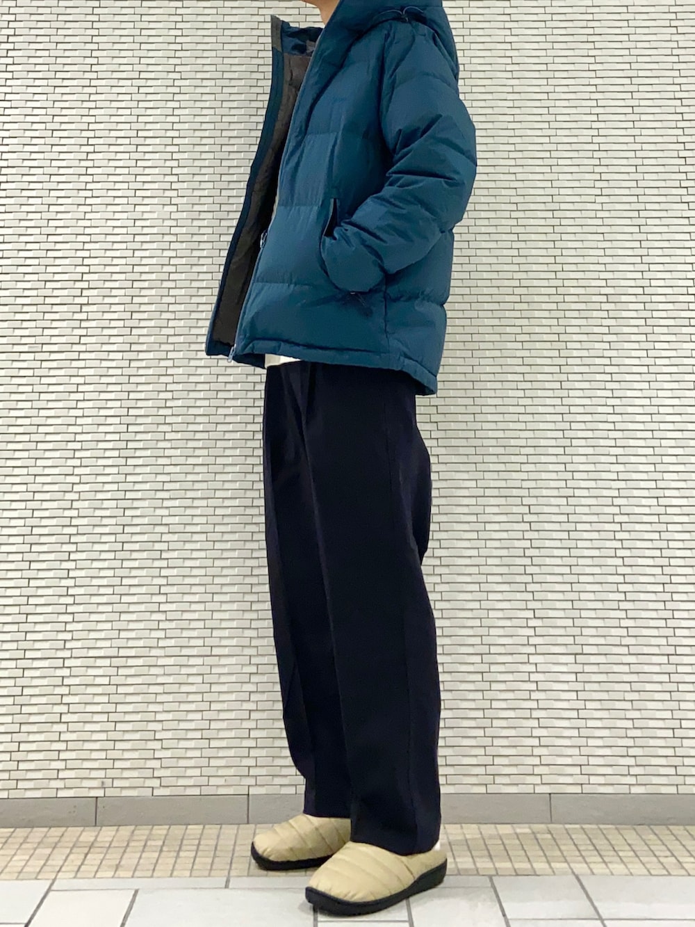 ブルー系のダウンジャケット/コート、ホワイト系のニット/セーター、ブルー系のその他パンツを着用したメンズの冬コーディネートの2枚目の写真