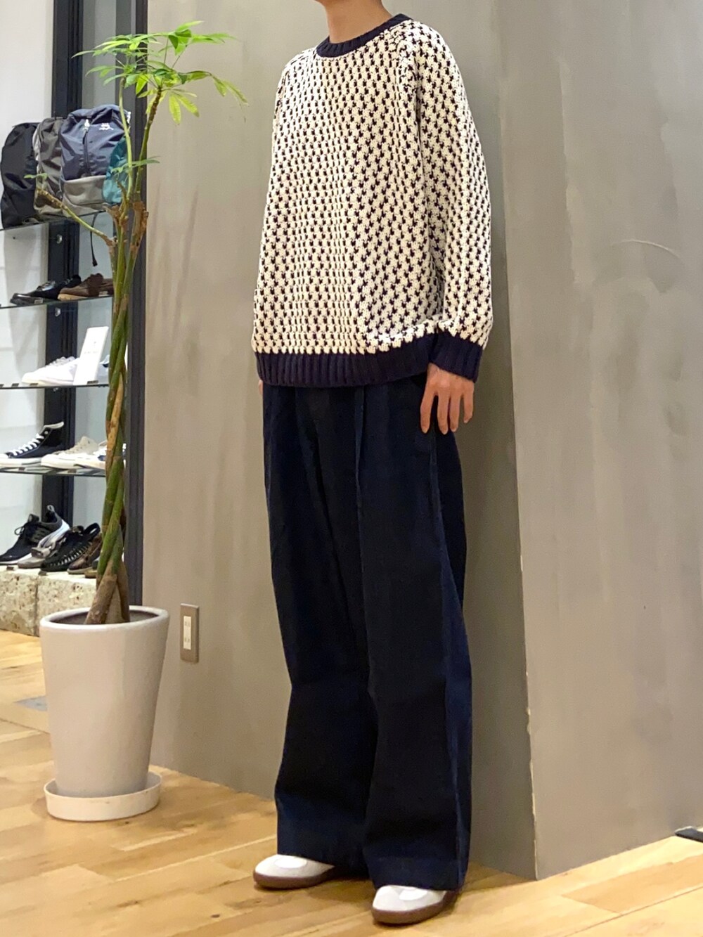 ホワイト系のニット/セーター、ブルー系のデニムパンツ、ホワイト系のスニーカーを着用したメンズの秋コーディネートの3枚目の写真