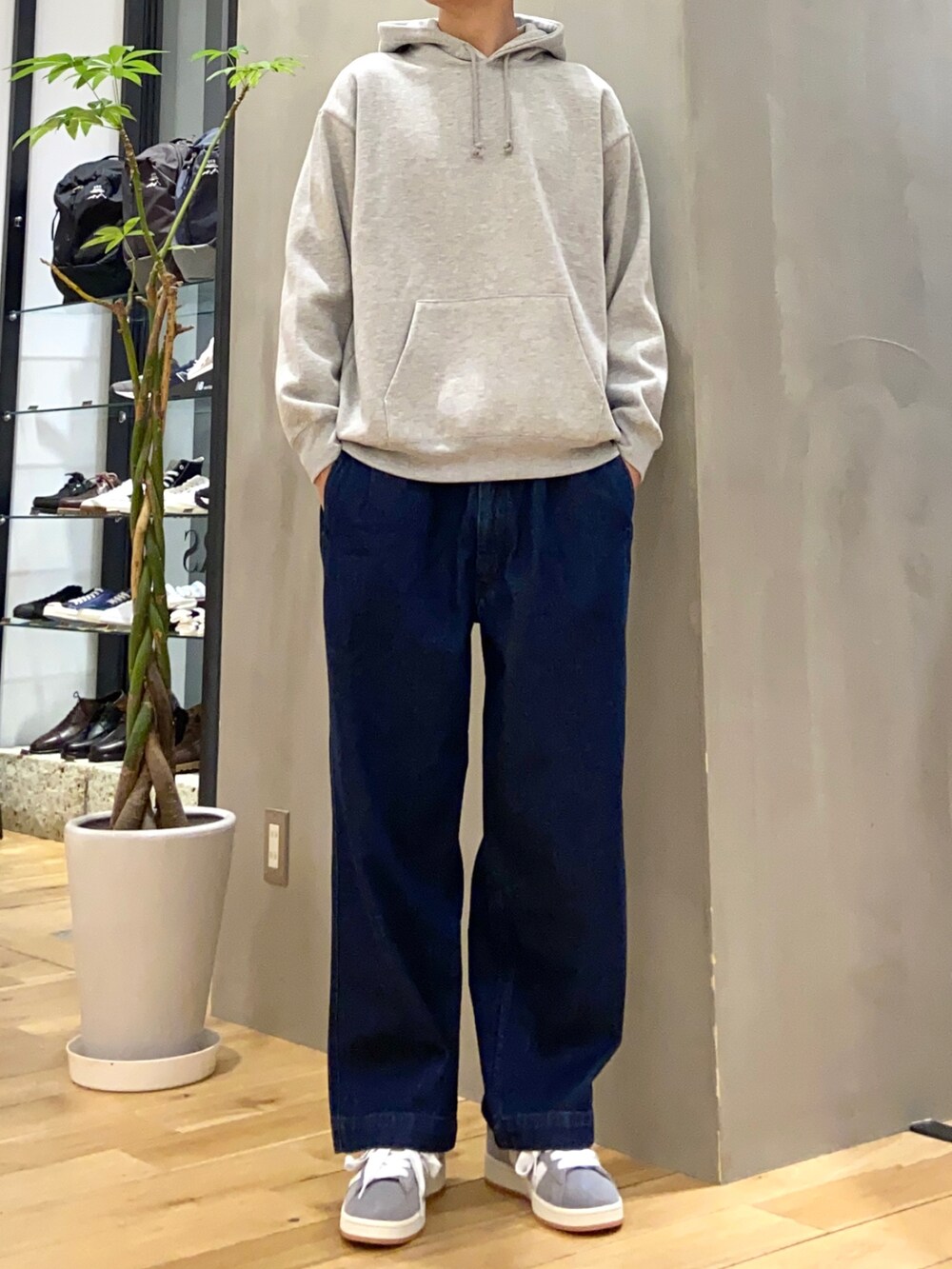 グレー系のパーカー、グリーン系のモッズコート、ブルー系のデニムパンツを着用したメンズの冬コーディネートの2枚目の写真