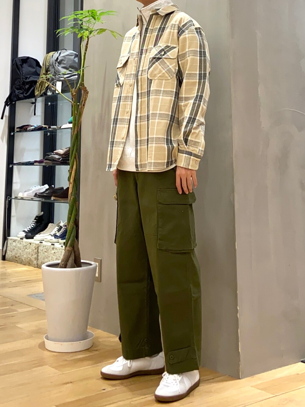 グレー系のスウェット、ベージュ系のシャツ/ブラウス、ホワイト系のスニーカーを着用したメンズの秋コーディネートの3枚目の写真