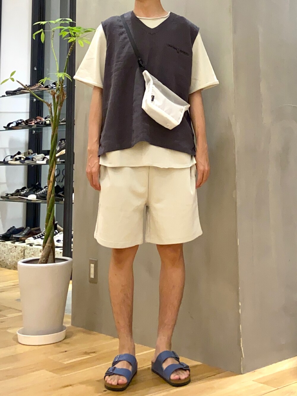 ブラック系のベスト、ホワイト系のショルダーバッグ、ブルー系のサンダルを着用したメンズの夏コーディネートの4枚目の写真