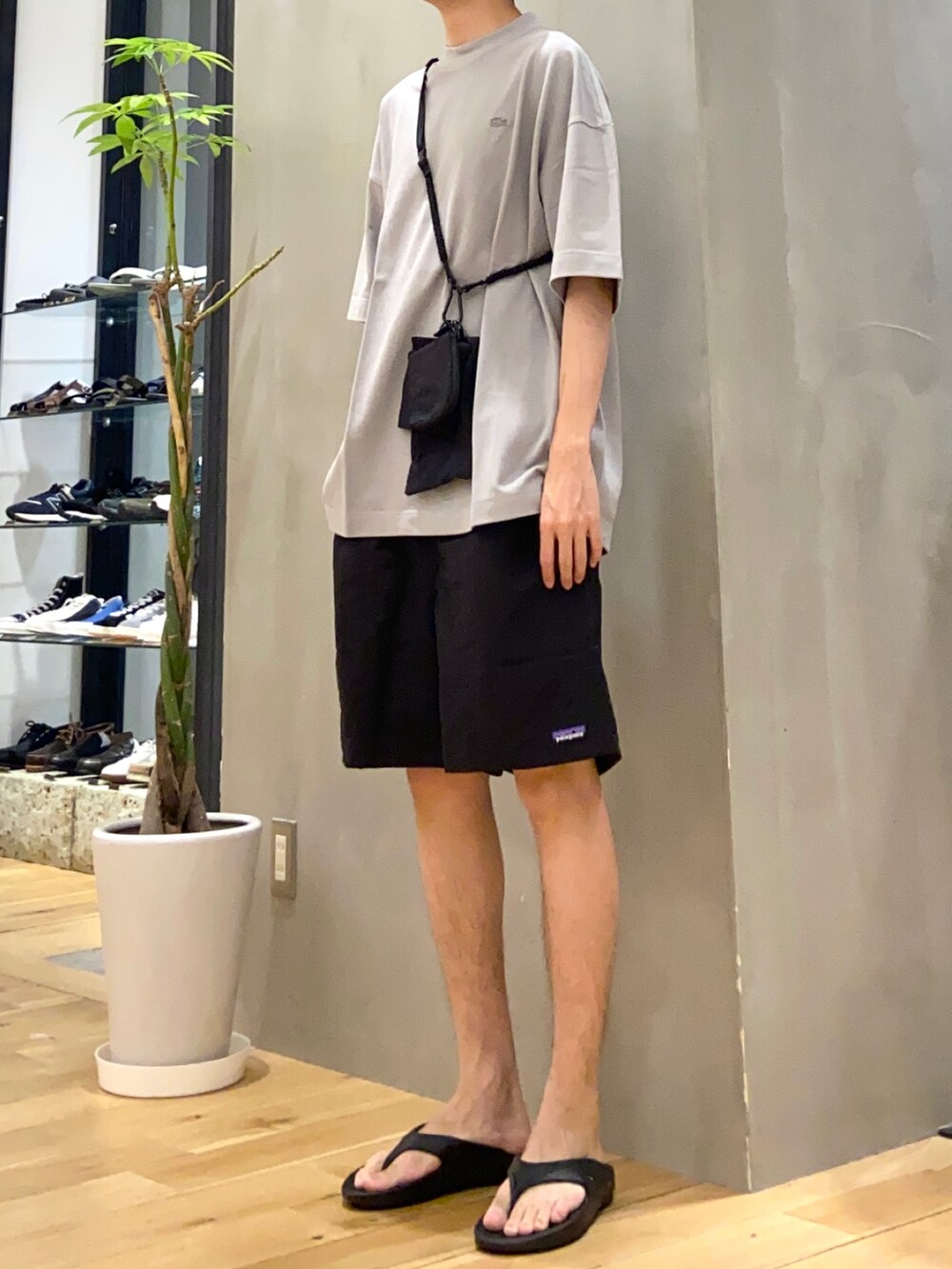 グレー系のTシャツ/カットソー、ブラック系のショルダーバッグ、ブラック系のサンダルを着用したメンズの夏コーディネートの2枚目の写真