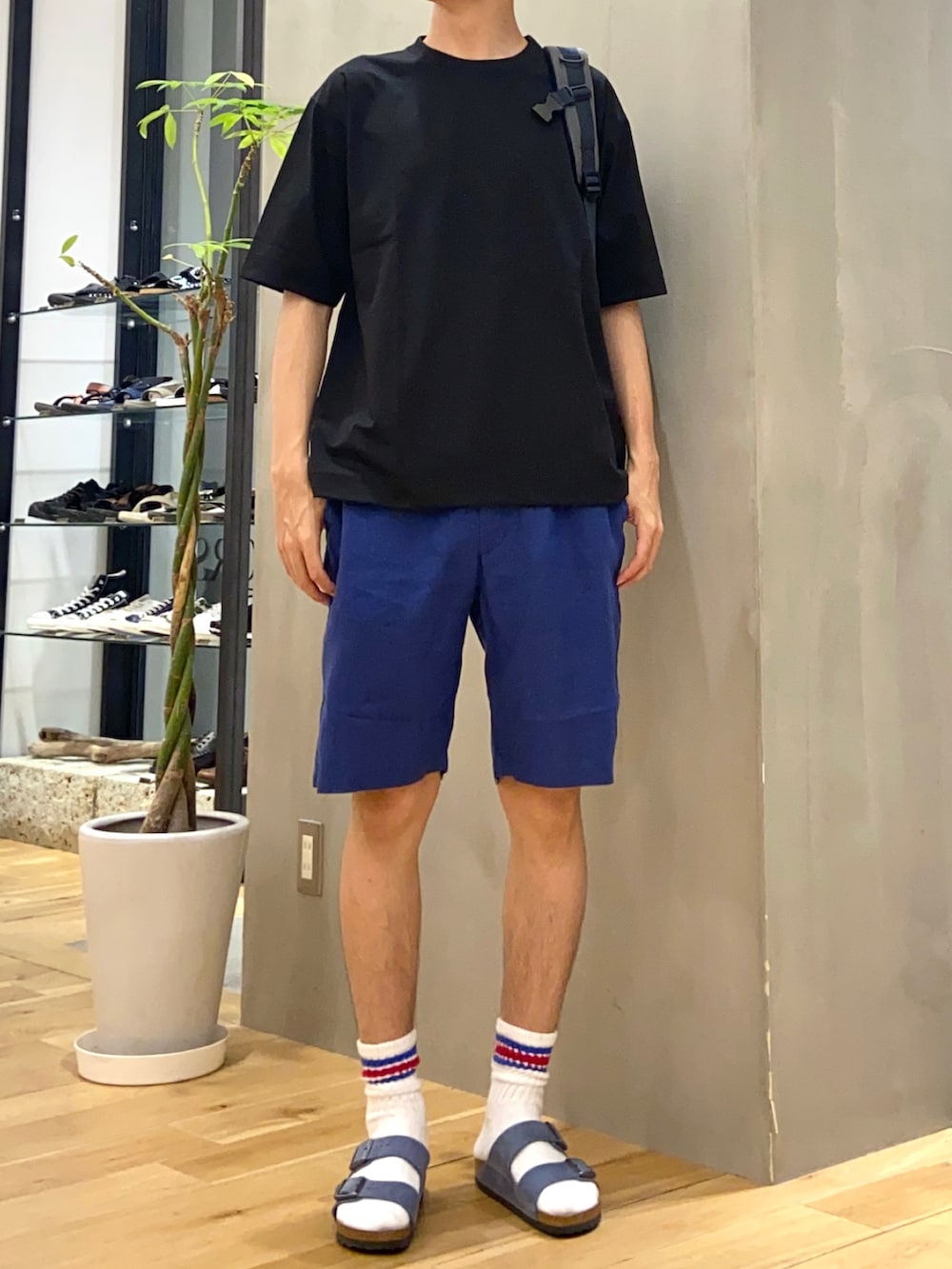 ブラック系のTシャツ/カットソー、ブルー系のその他パンツ、ブルー系のバックパック/リュックを着用したメンズの夏コーディネートの2枚目の写真