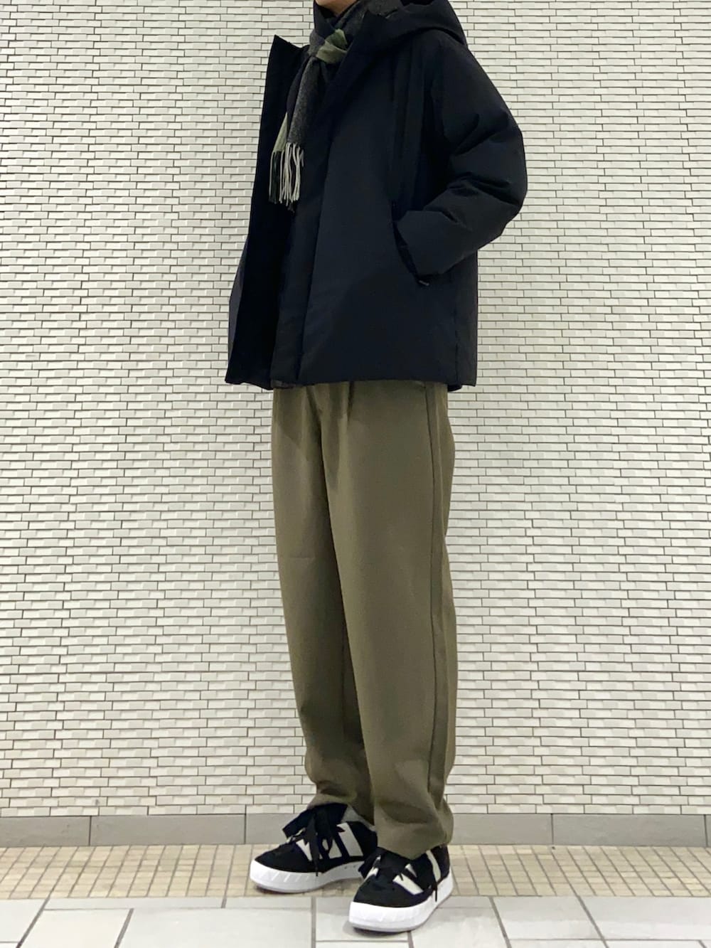 ブラック系のダウンジャケット/コート、ブラウン系のシャツ/ブラウス、グレー系のその他パンツを着用したメンズの冬コーディネートの3枚目の写真