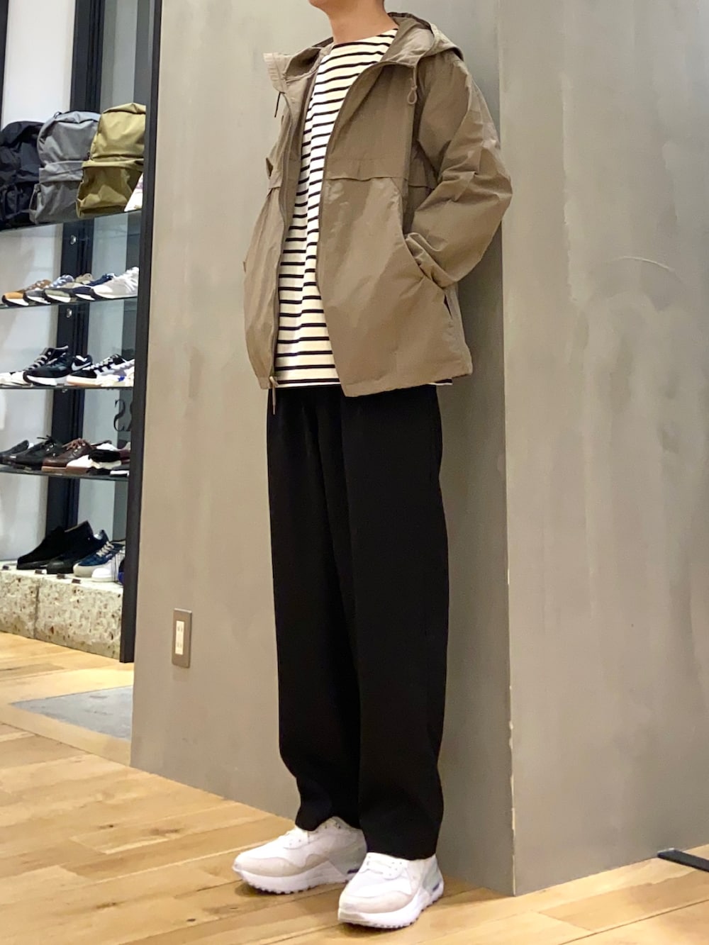 ベージュ系のマウンテンパーカー、ホワイト系のTシャツ/カットソー、ブラック系のその他パンツを着用したメンズの春コーディネートの2枚目の写真