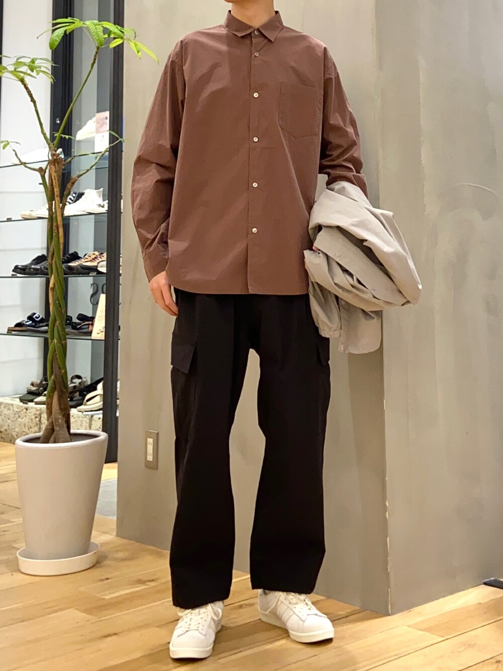 グレー系のナイロンジャケット、ブラウン系のシャツ/ブラウス、ベージュ系のスニーカーを着用したメンズの春コーディネートの2枚目の写真