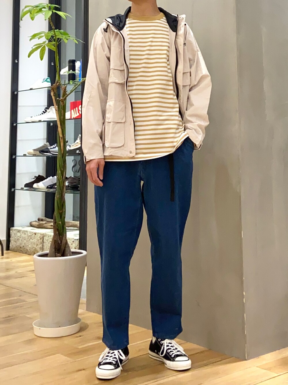 ベージュ系のマウンテンパーカー、イエロー系のTシャツ/カットソー、ブルー系のデニムパンツを着用したメンズの春コーディネートの3枚目の写真