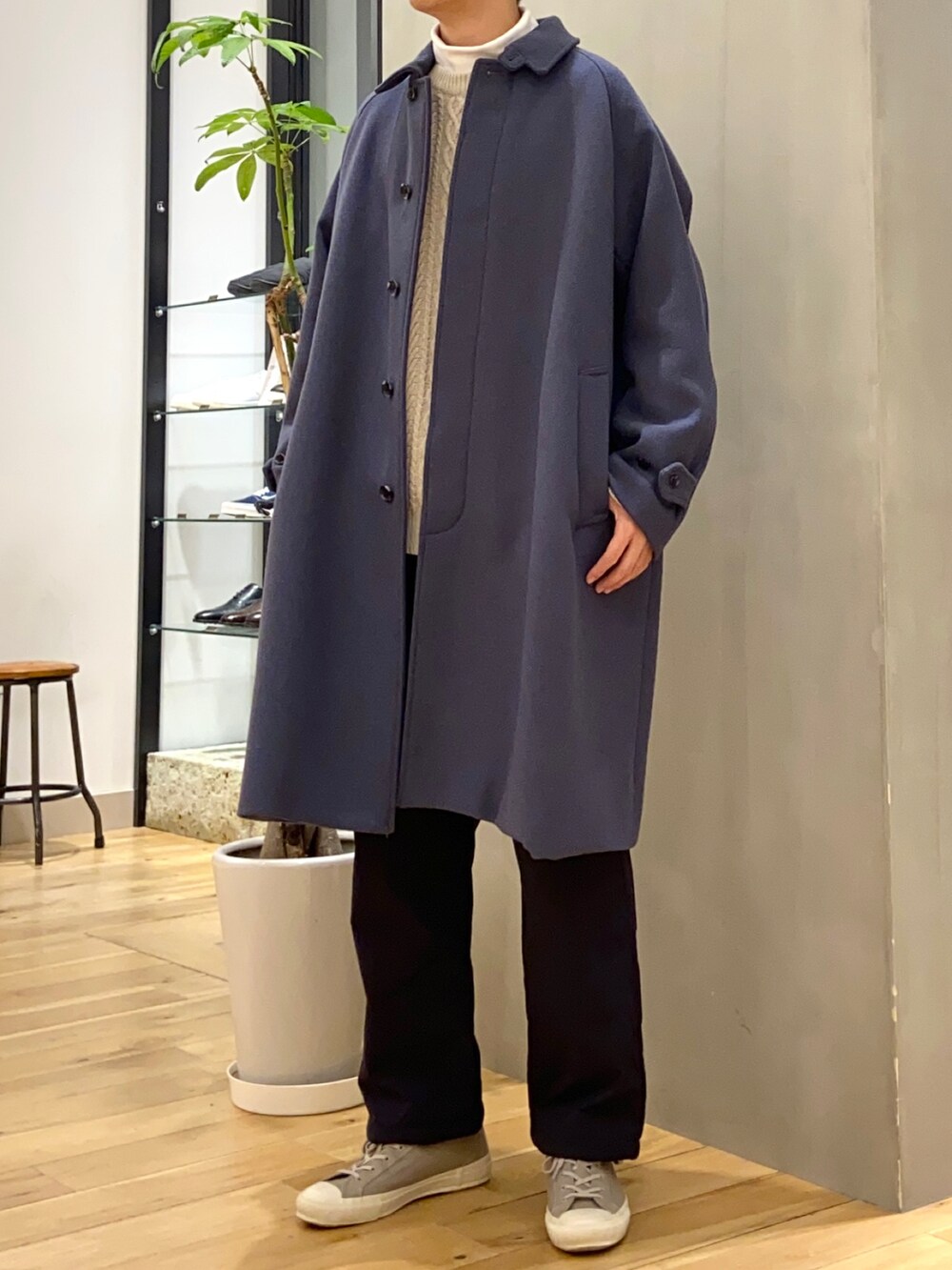 ホワイト系のTシャツ/カットソー、ベージュ系のニット/セーター、グレー系のスニーカーを着用したメンズの冬コーディネートの2枚目の写真