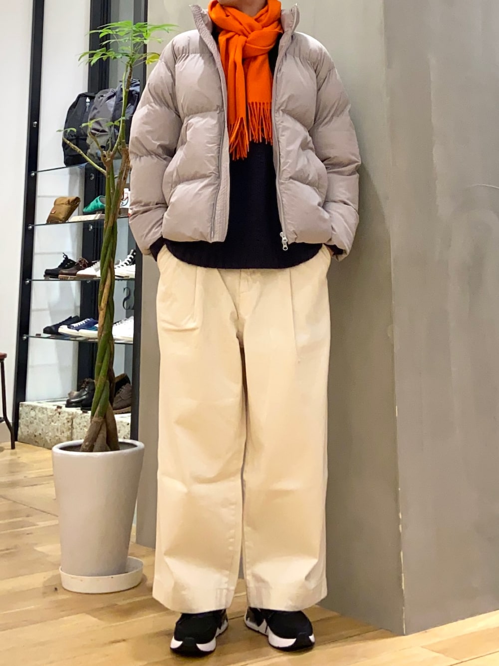 ブルー系のニット/セーター、ホワイト系のデニムパンツ、オレンジ系のマフラーを着用したメンズの冬コーディネートの3枚目の写真