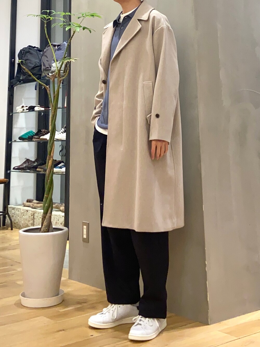 グレー系のチェスターコート、ホワイト系のTシャツ/カットソー、ブルー系のその他パンツを着用したメンズの冬コーディネートの4枚目の写真