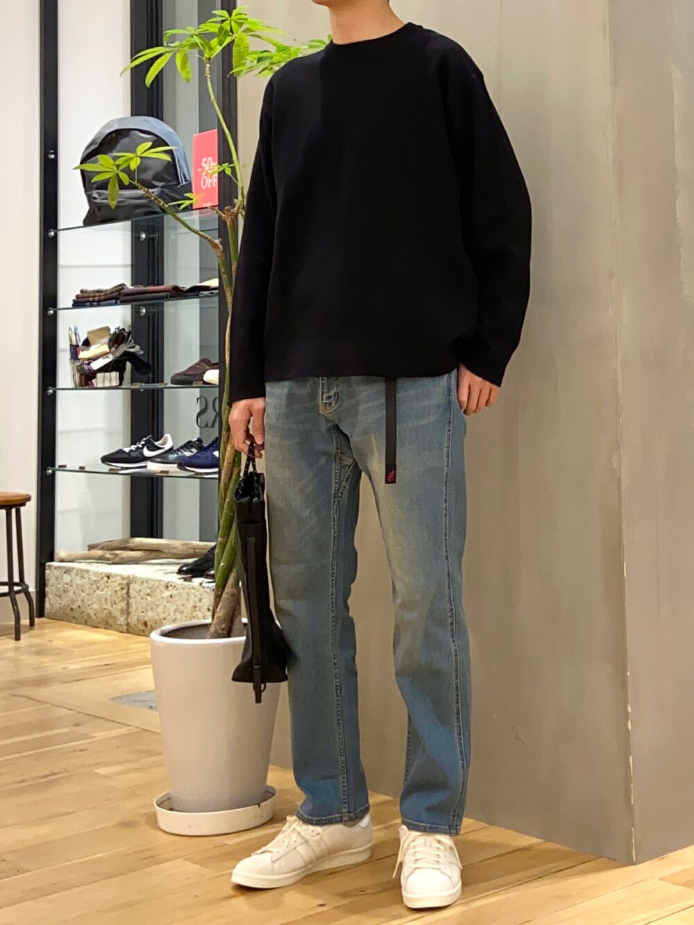 ブラック系のニット/セーター、ブルー系のその他パンツ、ベージュ系のスニーカーを着用したメンズの冬コーディネートの4枚目の写真