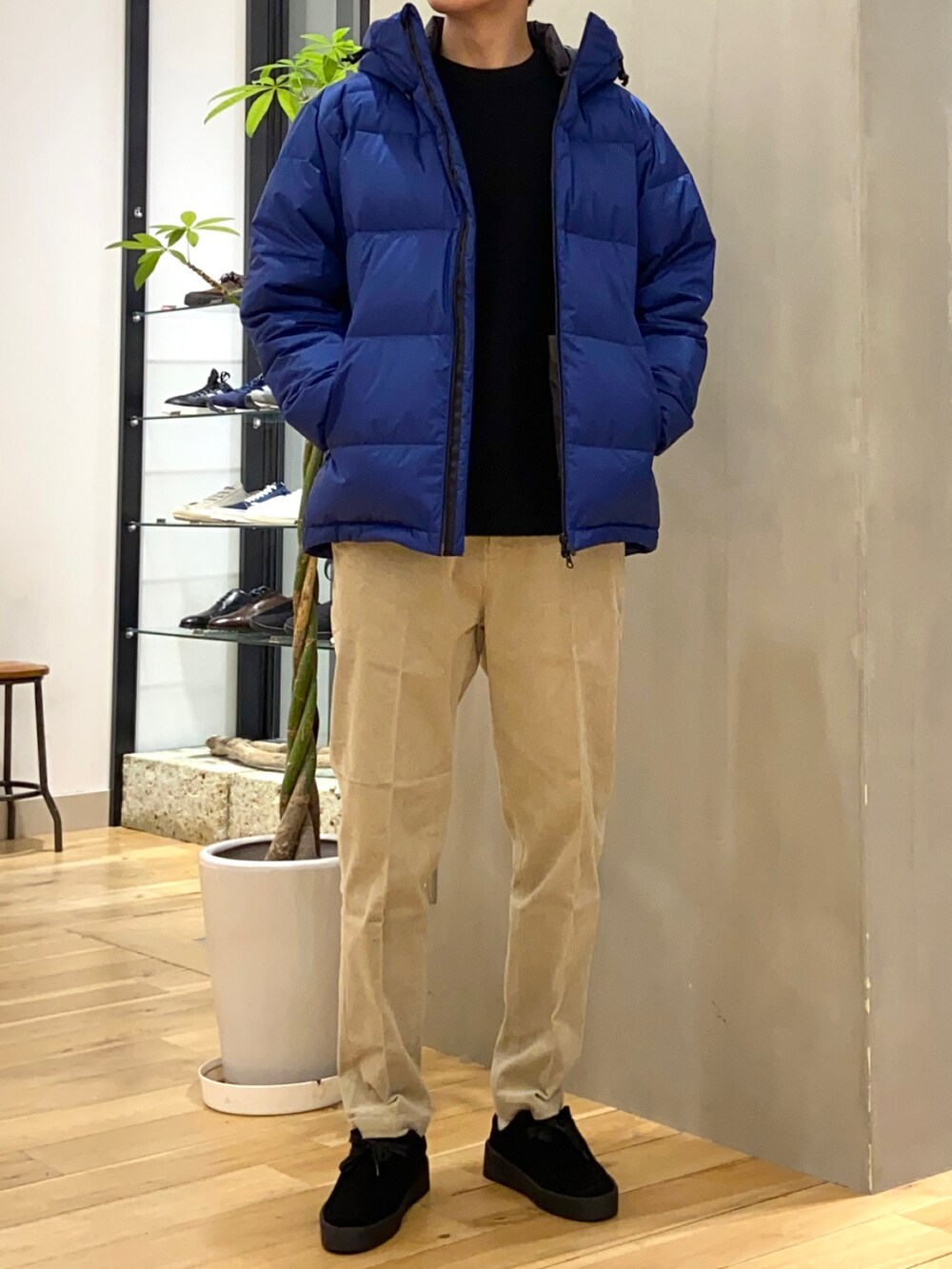 ブルー系のダウンジャケット/コート、ブラック系のニット/セーター、ブラック系のその他シューズを着用したメンズの冬コーディネートの3枚目の写真