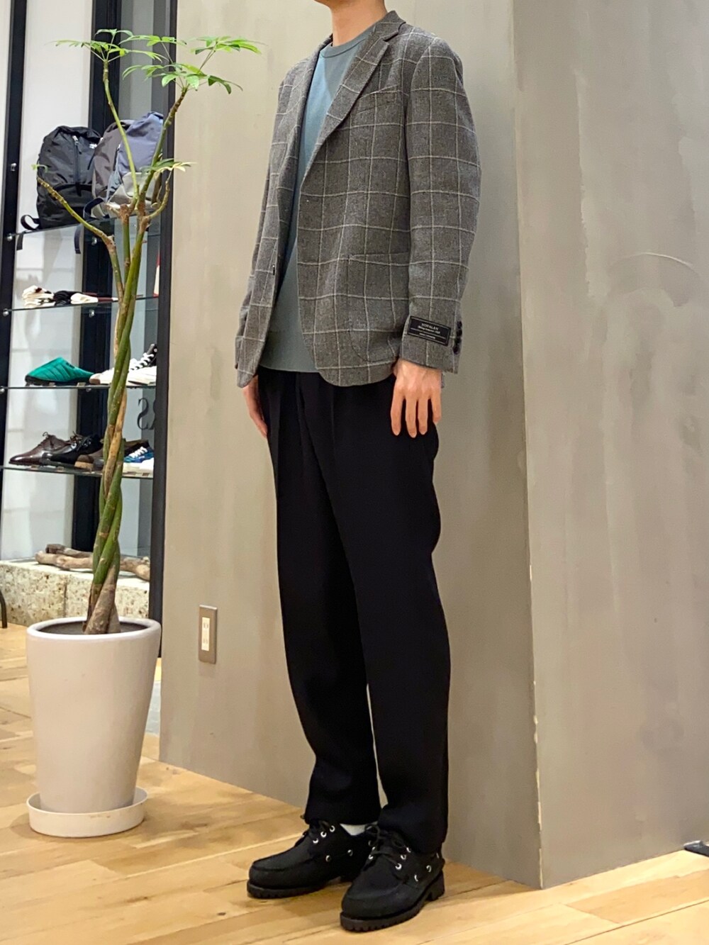 グレー系のスーツジャケット、グリーン系のニット/セーター、ブラック系のその他パンツを着用したメンズの春コーディネートの3枚目の写真