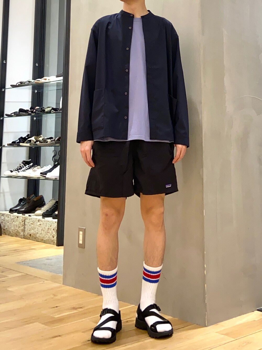 ブルー系のTシャツ/カットソー、ブルー系のブルゾン、ブラック系のサンダルを着用したメンズの春コーディネートの4枚目の写真