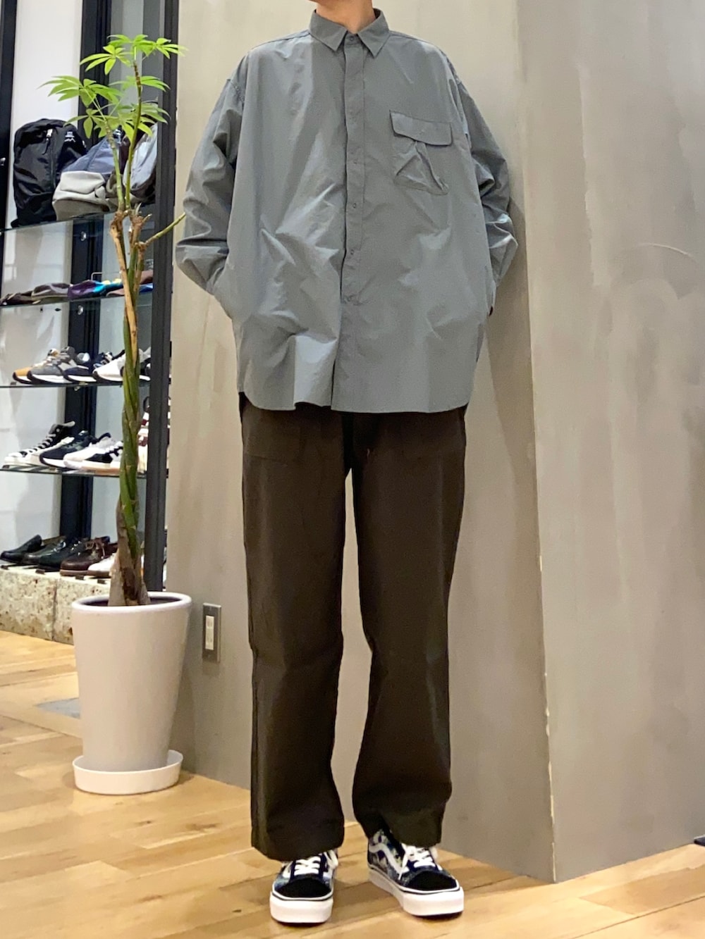 ブラック系のベスト、グレー系のシャツ/ブラウス、グリーン系のその他パンツを着用したメンズの春コーディネートの2枚目の写真