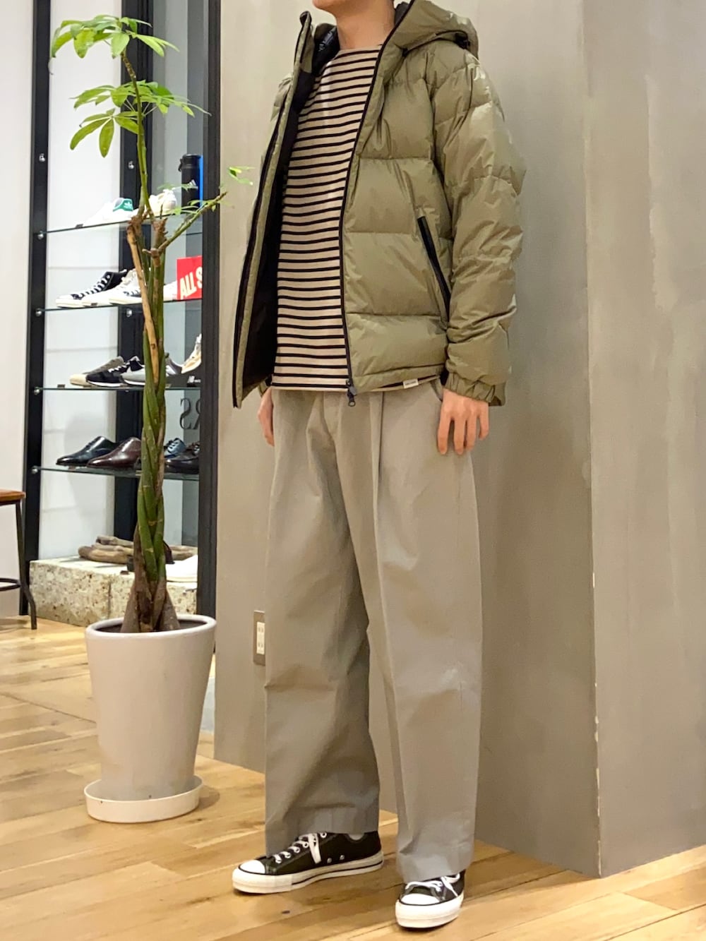 グリーン系のダウンジャケット/コート、ブラック系のTシャツ/カットソー、グレー系のその他パンツを着用したメンズの冬コーディネートの2枚目の写真