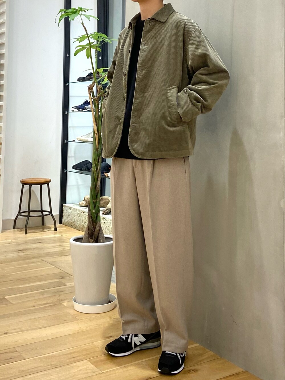 グリーン系のカバーオール、ブラック系のニット/セーター、ベージュ系のその他パンツを着用したメンズの秋コーディネートの2枚目の写真