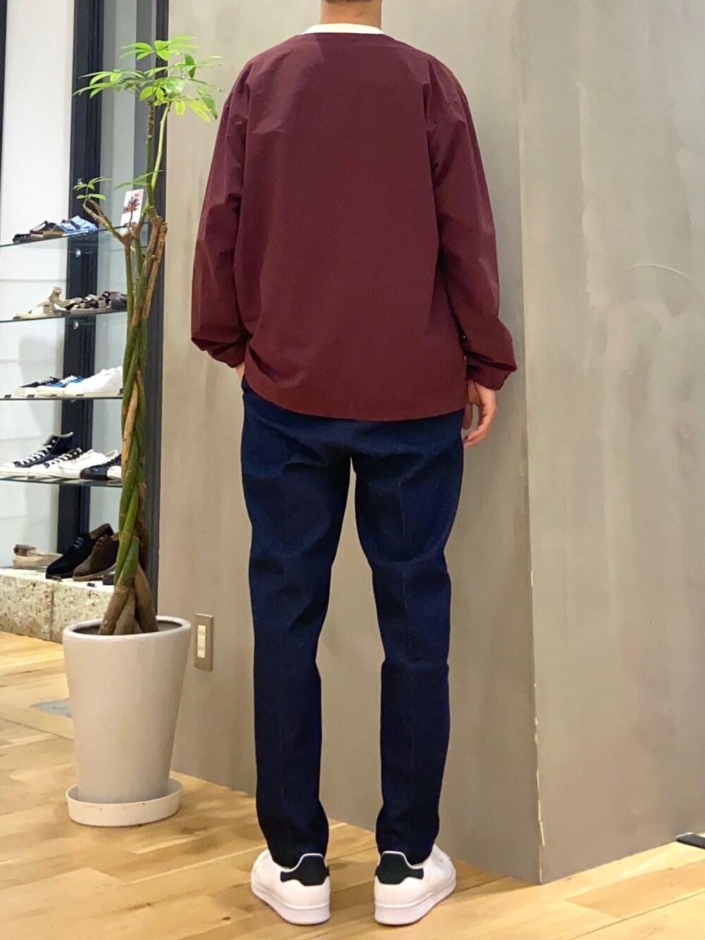 レッド系のブルゾン、ホワイト系のTシャツ/カットソー、ブルー系のデニムパンツを着用したメンズの秋コーディネートの3枚目の写真