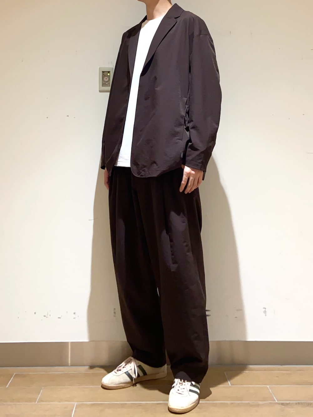 ブラウン系のその他アウター、ブラウン系のその他パンツ、ホワイト系のTシャツ/カットソーを着用したメンズの春コーディネートの4枚目の写真