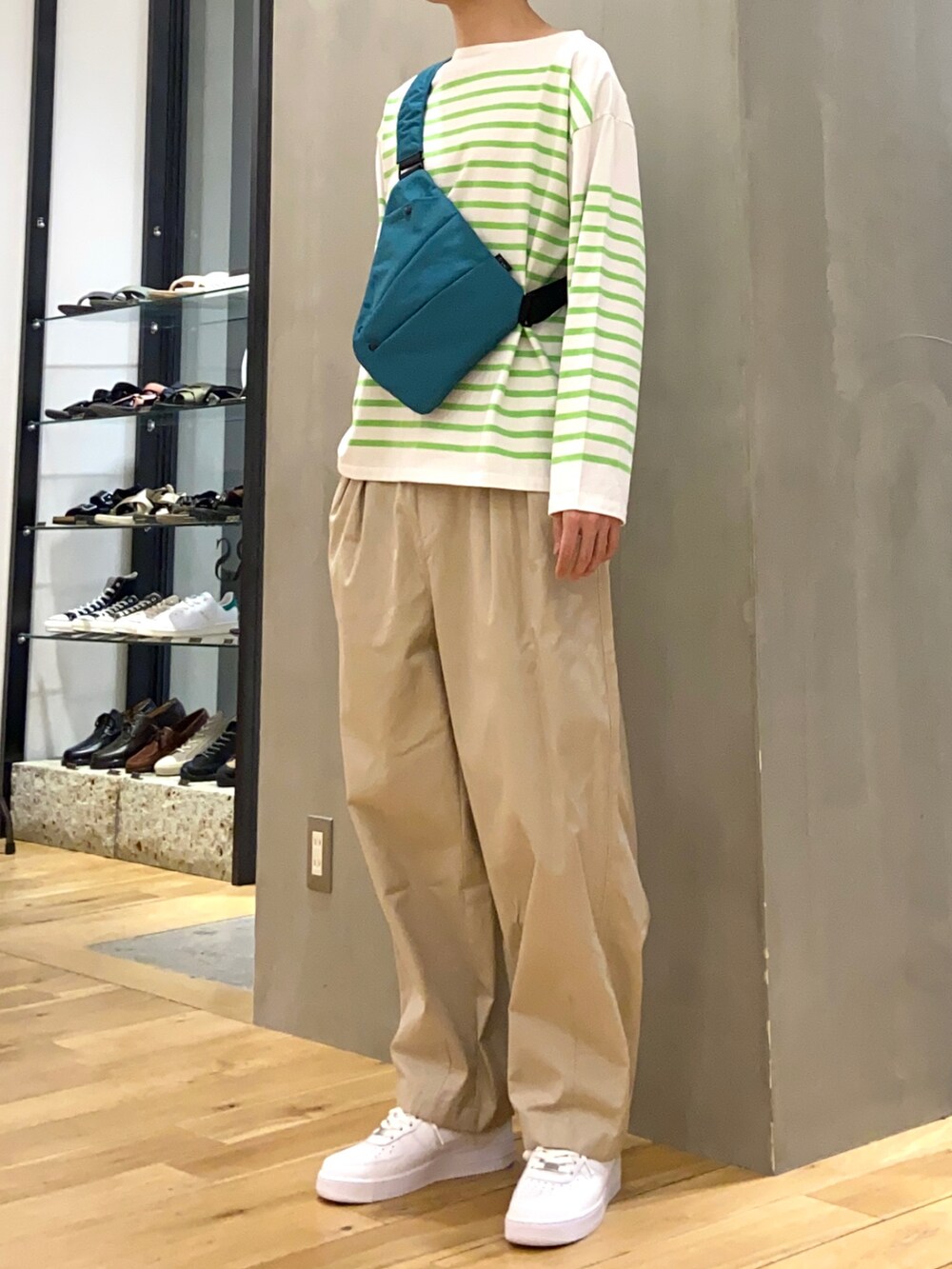 グリーン系のTシャツ/カットソー、グリーン系のショルダーバッグ、ベージュ系のその他パンツを着用したメンズの春コーディネートの3枚目の写真