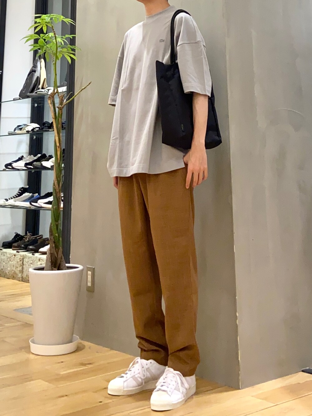 グレー系のTシャツ/カットソー、ブラウン系のその他パンツ、ブラック系のトートバッグを着用したメンズの春コーディネートの2枚目の写真