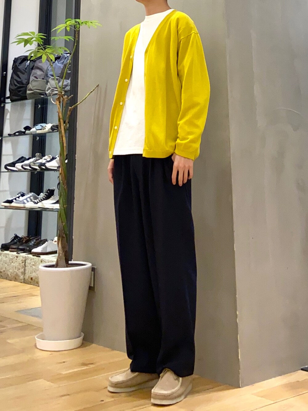 イエロー系のカーディガン/ボレロ、ホワイト系のTシャツ/カットソー、ブルー系のスラックスを着用したメンズの春コーディネートの4枚目の写真