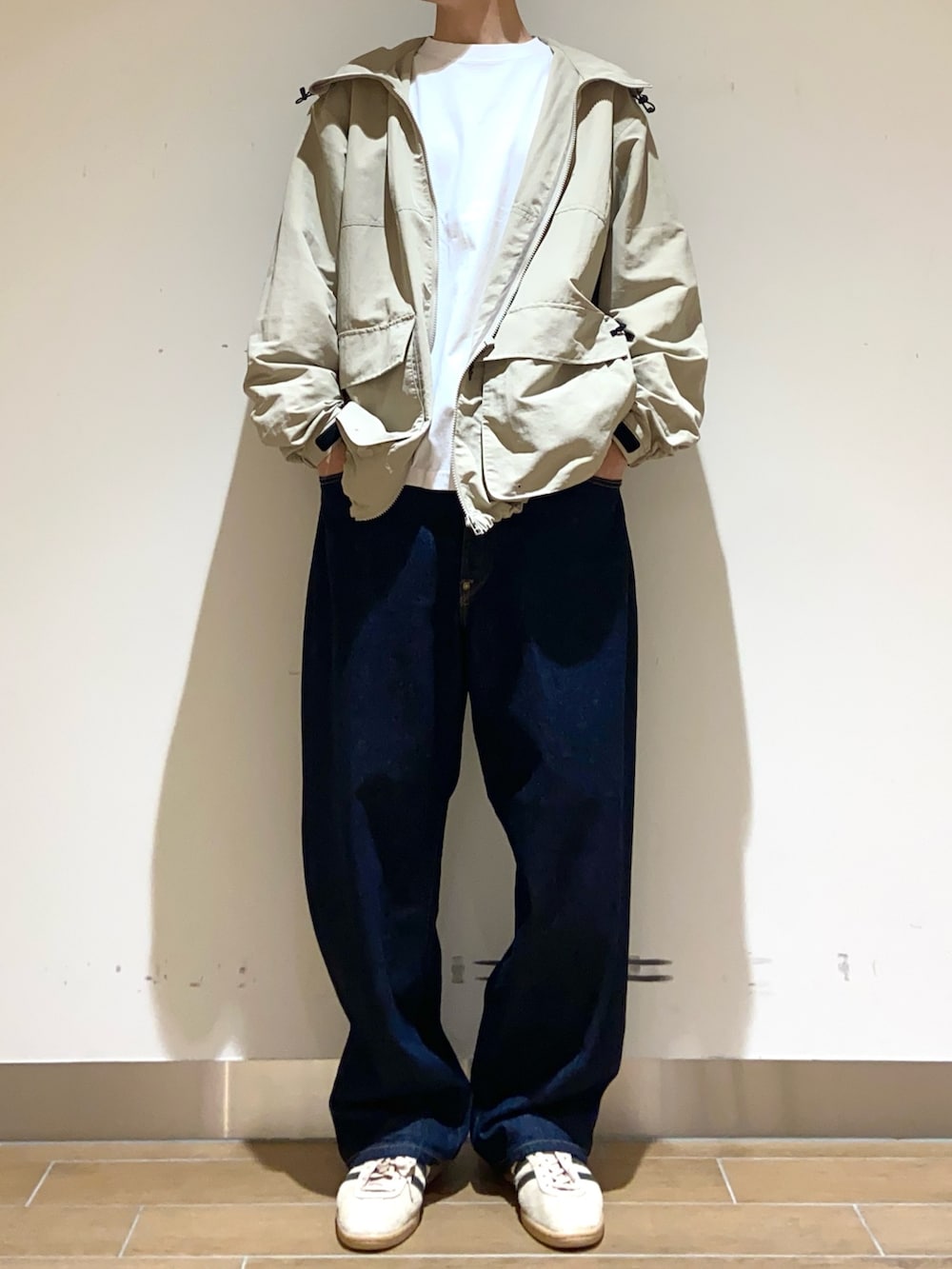 ベージュ系のマウンテンパーカー、ホワイト系のTシャツ/カットソー、ブルー系のデニムパンツを着用したメンズの春コーディネートの3枚目の写真